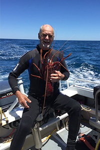 FSH mesothelioma Biobank patient holds a cray on the deck of a boat in the ocean
