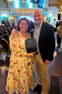 Clare Oudmand holding her award on the evening of the event, pictured with SMHS CE Neil Doverty. 