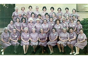 A photo from 1983 of a group of about 40 women wearing the lavender uniforms of the Fremantle Hospital Ladies Auxiliary.