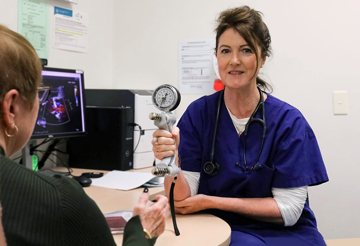 FSH Valve Intervention Program Coordinator & Nurse Practitioner, Jen Turner, sits in front a patient. Jen is holding an item of medical equipment so she can do a frailty assessment.