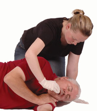 Woman clearing man&rsquo;s mouth cavity with fingers.